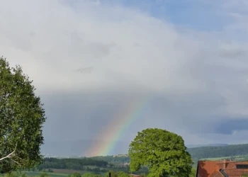 Regenbogen über den Hügeln und Wiesen des Extertals nach einem Regenschauer
